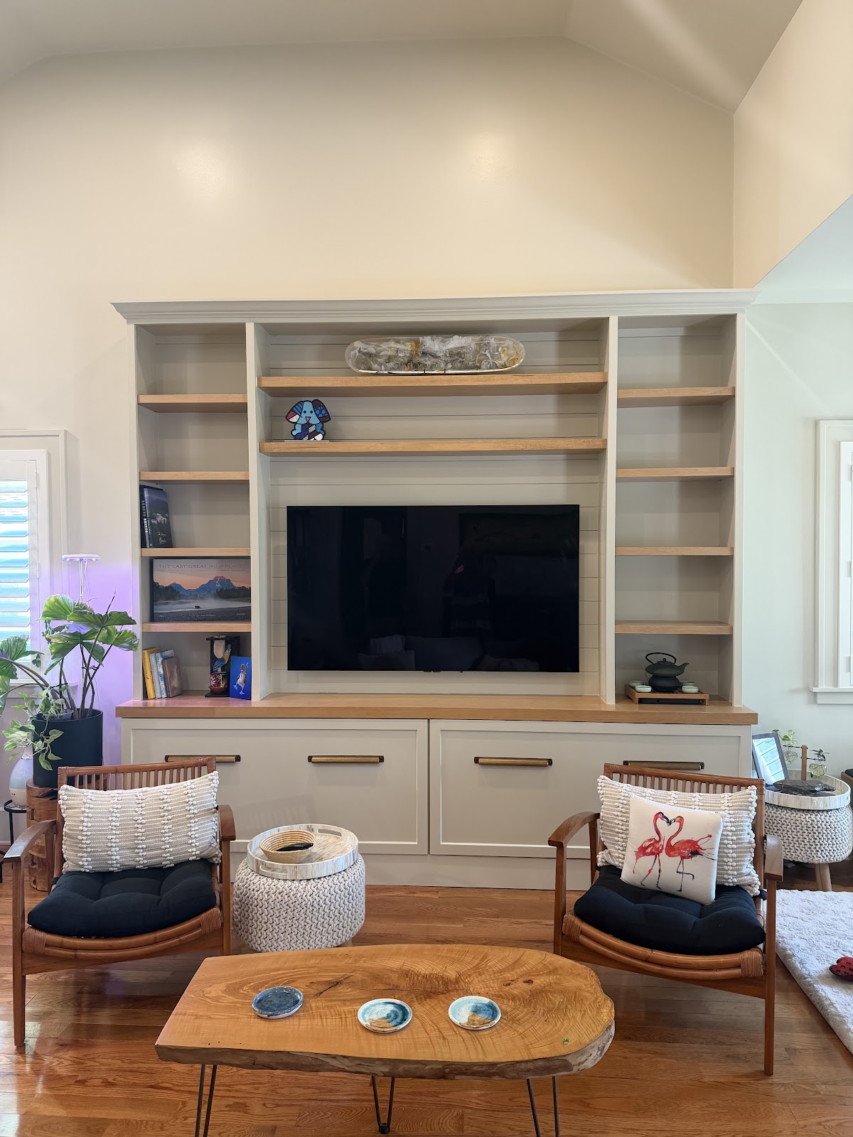 Custom white media cabinetry with wood shelves in a finished living room by Frost Custom Carpentry