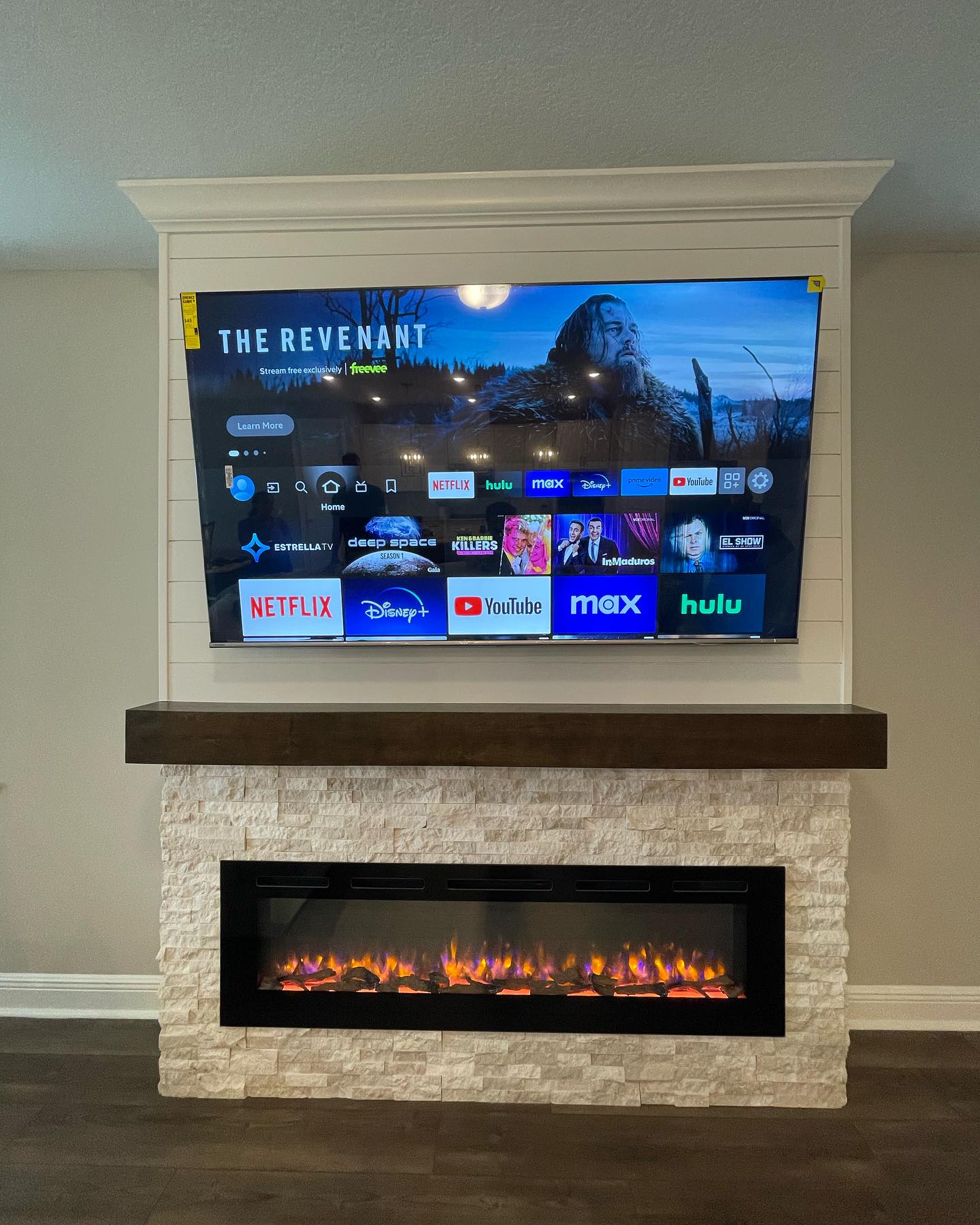 Stone fireplace surround below a paneled media wall